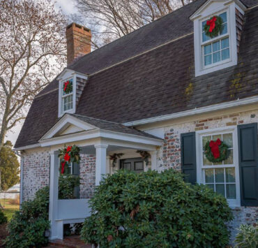 Outside of a historical home decorated with wreaths