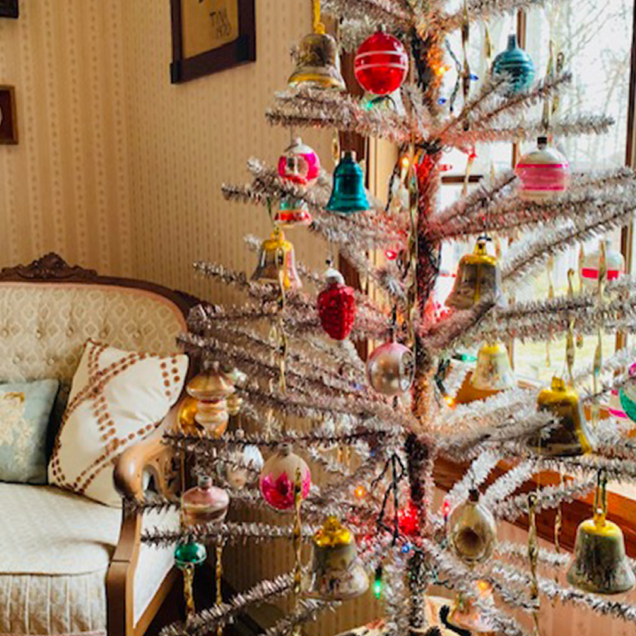 Christmas tree decorated with ornaments inside of a home