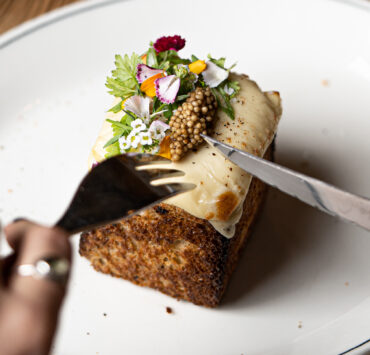 Person about to dig into a small gourmet dish