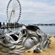Giant statue face buried in sand at National Harbor