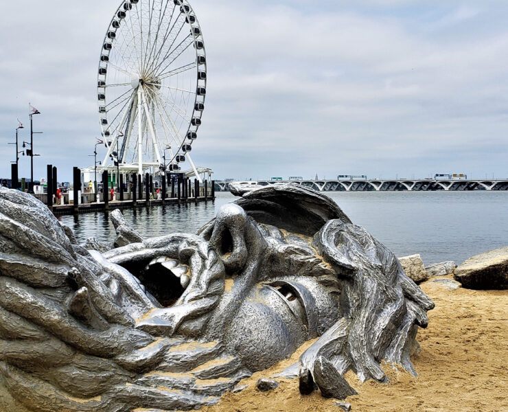 Giant statue face buried in sand at National Harbor