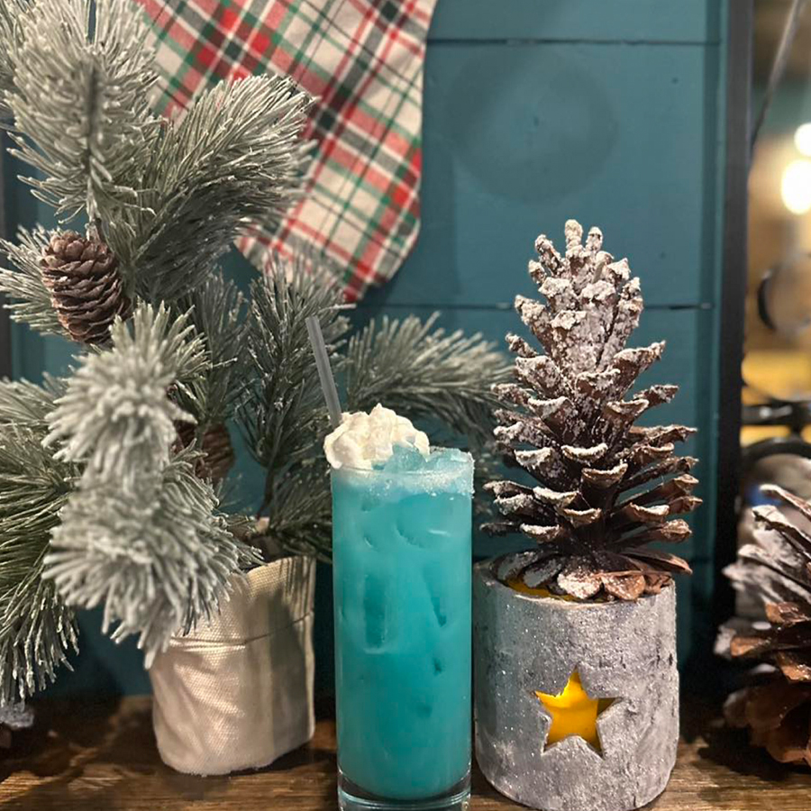 Festive blue cocktail with winter decorations