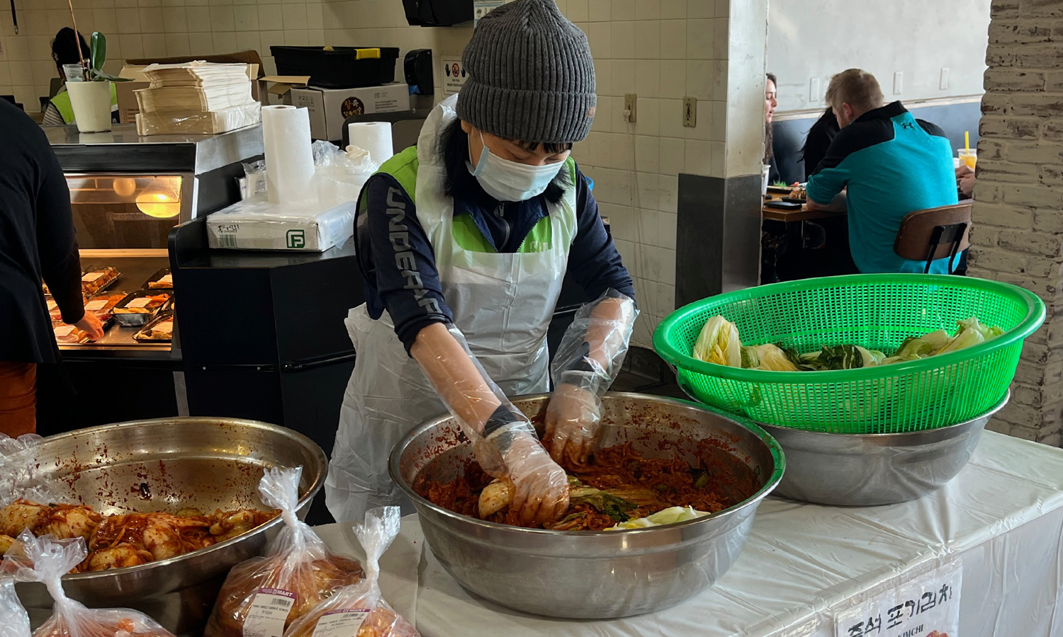 Person making large batch of kimchi