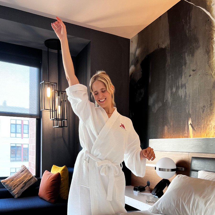 Person stretching in a robe in a hotel room