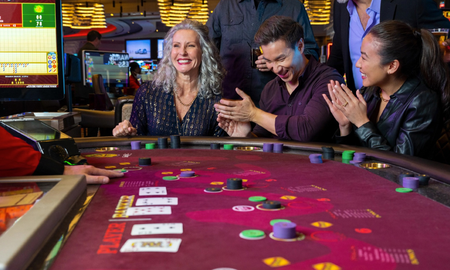 Group of people laughing at a table in a casino