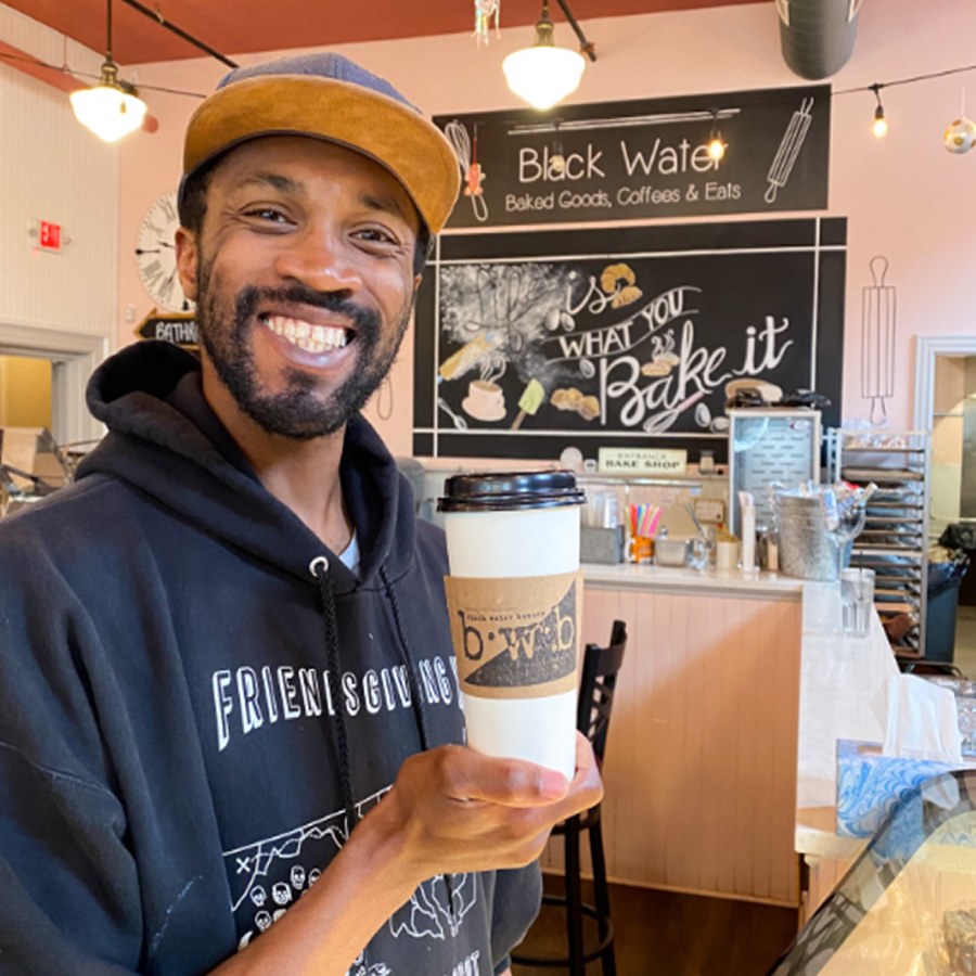 Person holding up coffee at a coffeeshop