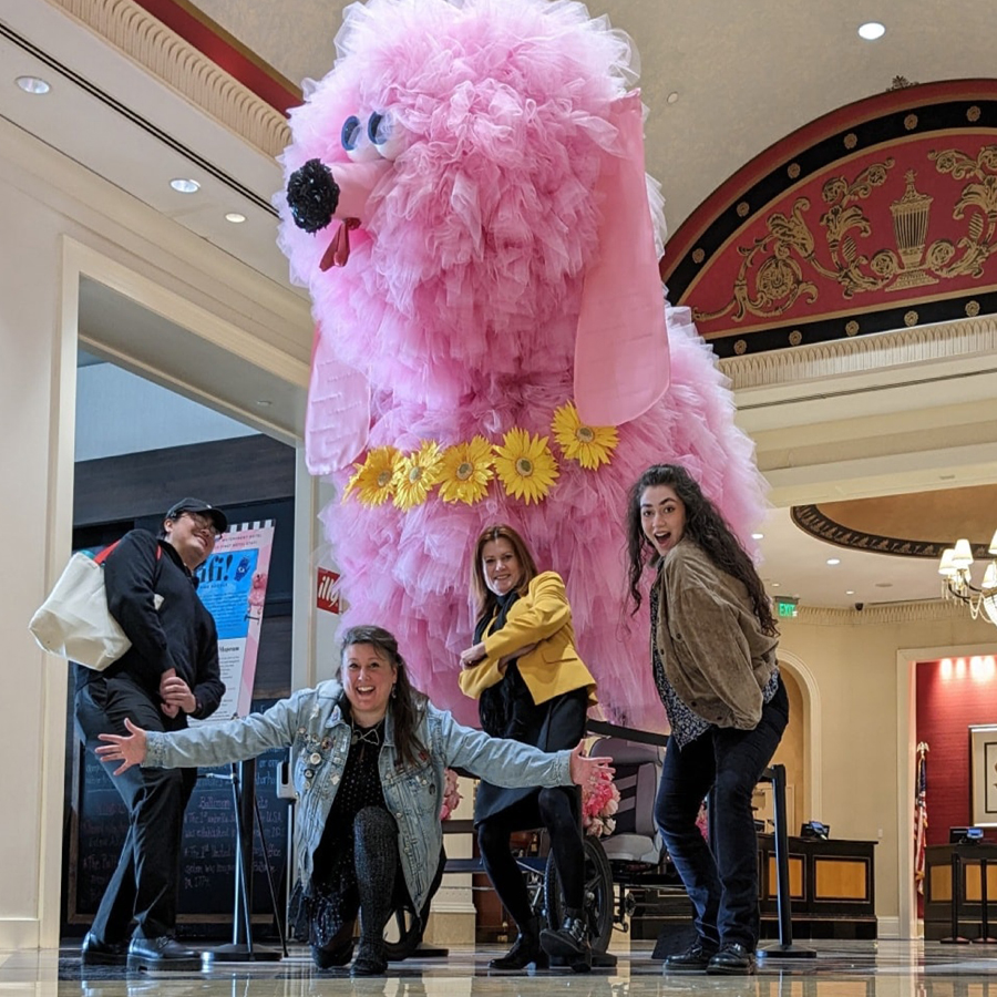 Group poses in front of giant pink statue